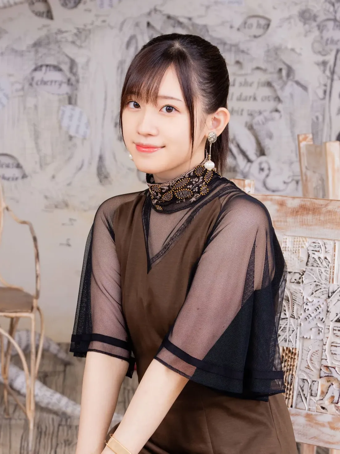 voice actress Rie Takahashi sitting and smiling.